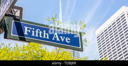 Fifth Ave street sign, Manhattan New York downtown. Panneau bleu sur la façade des bâtiments flou et fond de ciel bleu, Banque D'Images