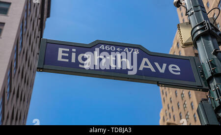 Huitième ave street sign, Manhattan New York downtown. Panneau bleu sur la façade des bâtiments flou et fond de ciel bleu, Banque D'Images