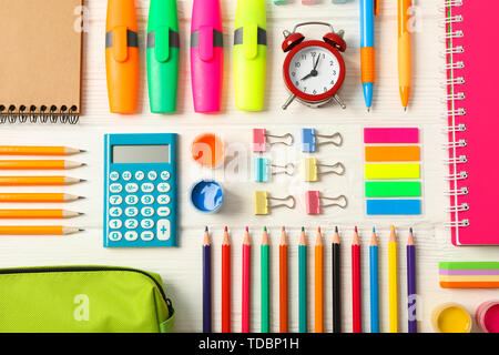 Télévision jeter la composition avec les fournitures scolaires sur fond de bois blanc Banque D'Images