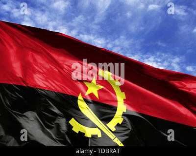 Waving Flag de l'Angola close up against blue sky Banque D'Images