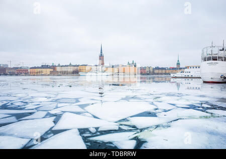 Vue d'hiver de la vieille ville de Stockholm, Gamla Stan et Riddarholm Eglise, avec des bateaux amarrés dans le lac gelé menant à la mer Baltique. Banque D'Images