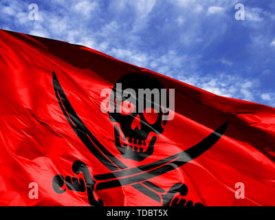 Waving Flag de Pirates red close up against blue sky Banque D'Images