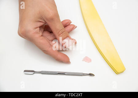 L'enlèvement du vieux matériel shellac depuis les ongles dans le salon par le maître Banque D'Images