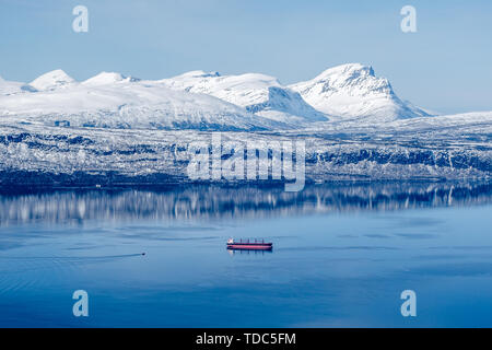 Un navire de marchandises en attente de remorqueur approchait à quai pour le minerai de fer à Narvik en Norvège fjord en hiver Banque D'Images