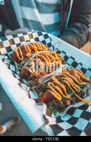 Trois délicieux carne de bœuf asada tacos couverts de rouge et les sauces jaunes Banque D'Images