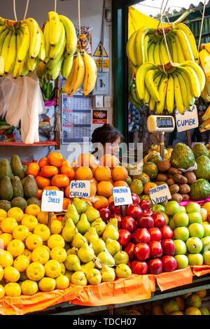 Lima / Pérou - Mai 20,2008 : vue sur le marché stand rempli de fruits colorés comme les bananes, les citrons et les aples, femme Latino vendeur debout. Banque D'Images