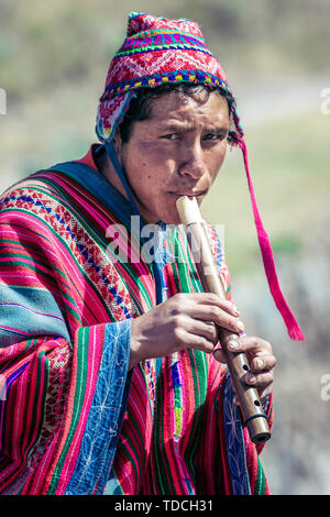 Cusco Pérou - Mai 29,2008 : Portrait d'un homme, berger, éleveur de chèvres, habillés en costume autochtone,coin sur le rocher et de jouer sur la flûte. Banque D'Images