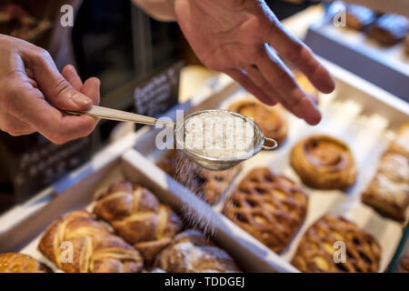 Woman sweet blanc en poudre sur les cookies à la boulangerie. Banque D'Images