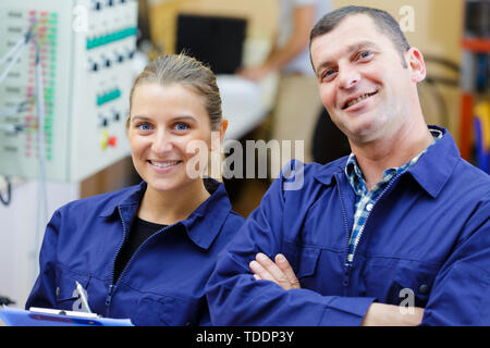 Deux employés du centre de service auto heureux portrait intérieur d'atelier Banque D'Images