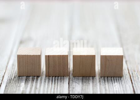 Quatre cubes en bois gris sur fond de bois Banque D'Images