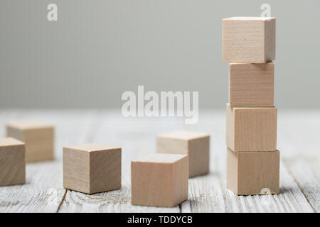 Quatre cubes en bois gris sur fond de bois Banque D'Images