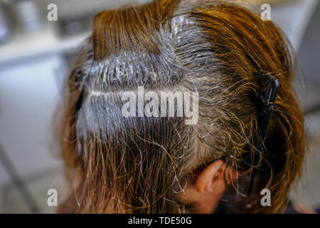 Gros plan de cheveux foncés ayant les racines de couleur. Une séparation avec la teinte appliquée. Banque D'Images