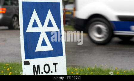 Service MOT bleu signe sur la route le jour de pluie nuageux Banque D'Images