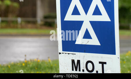 Service MOT bleu signe sur la route le jour de pluie nuageux Banque D'Images