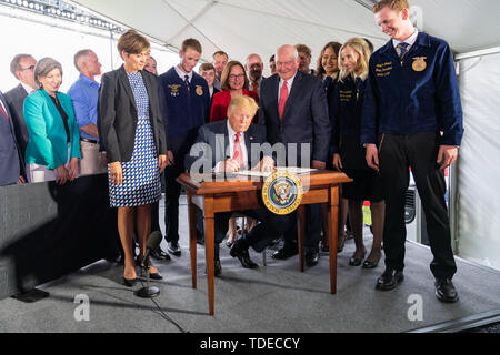 Bluffs, États-Unis d'Amérique. 11 Juin, 2019. Le président Donald J. Trump, accompagné du secrétaire de l'Agriculture Sonny Perdue, Gouverneur de l'Iowa Kim Reynolds, membres de l'avenir de l'Amérique, les agriculteurs et les fonctionnaires locaux, signe un ordre exécutif sur la modernisation du cadre réglementaire pour les produits de la biotechnologie agricole Mardi, 11 juin 2019, à l'énergie renouvelable dans le sud-ouest de l'Iowa Council Bluffs, Iowa People : Le président Donald Trump Credit : tempêtes Media Group/Alamy Live News Banque D'Images