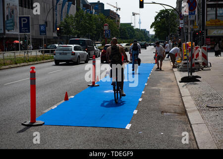 Berlin, Allemagne. 15 Juin, 2019. Cyclistes roulent sur une bande de stationnement bleu Müllerstraße. Là, des militants de l'évolution des villes avait appelé à une action. Les militants de la bicyclette a créé une voie cyclable protégée temporairement (pistes cyclables protégées/PBL) sur Müllerstraße. Crédit : Paul Zinken/dpa/Alamy Live News Banque D'Images