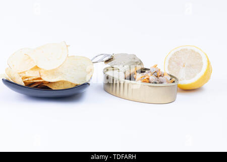 De délicieux en-cas de conserves de coques et de frites avec citron frais en isolé dans un fond blanc Banque D'Images