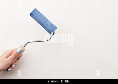 Peinture main de femme mur avec rouleau dans la couleur bleue, copy space Banque D'Images