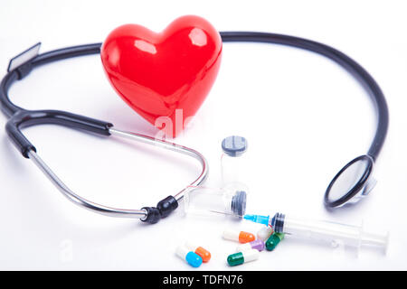 Amour rouge stéthoscope et sur la table des matières médicinales Banque D'Images