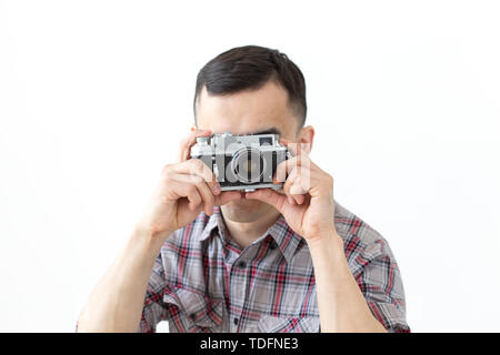 Loisirs et passe-temps de personnes concept - young asian man en utilisant son appareil photo vintage sur fond blanc Banque D'Images