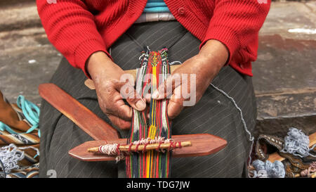 Femme péruvienne tisse avec des threads sur une rue à Cusco, Pérou Banque D'Images