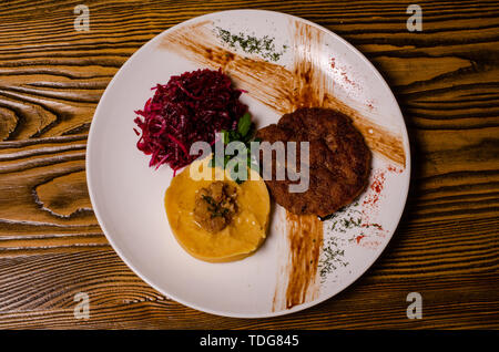 Libre de deux morceaux de viande grillés brute moyenne décoré avec le poivron rouge et la sauce servi avec frites et salade de légumes sur le restaurant black pla Banque D'Images