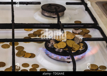 Flammes bleues de la combustion de gaz naturel d'une cuisinière à gaz sur un arrière-plan de la monnaie. Banque D'Images