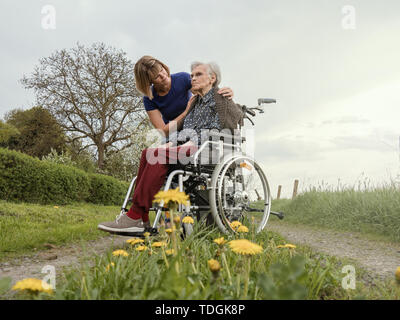Jeune femme avec grand-mère en fauteuil roulant Banque D'Images