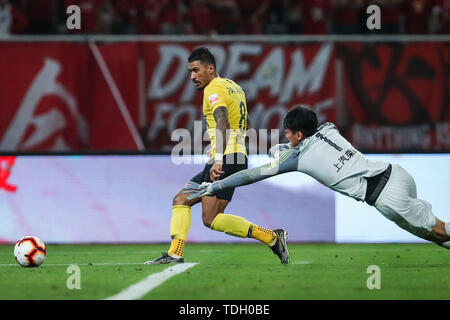 Joueur de football brésilien Paulinho, gauche, de Guangzhou Evergrande Taobao coups la balle contre Shanghai EPOP dans leur 13e match au cours de l'Association de football chinoise 2019 Super League (CSL) à Shanghai, Chine, le 14 juin 2019. Epop Shanghai Guangzhou Evergrande est défait par Taobao 0-2. Banque D'Images