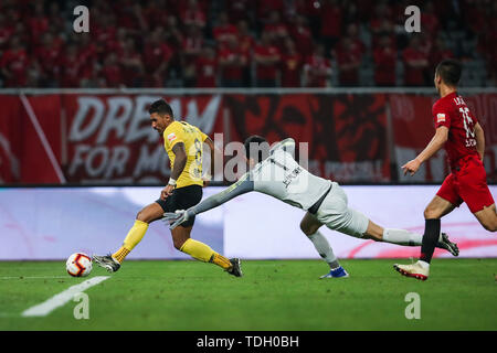 Joueur de football brésilien Paulinho, gauche, de Guangzhou Evergrande Taobao coups la balle contre Shanghai EPOP dans leur 13e match au cours de l'Association de football chinoise 2019 Super League (CSL) à Shanghai, Chine, le 14 juin 2019. Epop Shanghai Guangzhou Evergrande est défait par Taobao 0-2. Banque D'Images