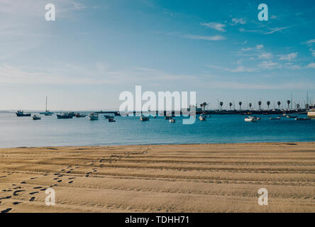 Vide de sable Praia do Ribeiro et bateaux sur une baie d'un matin d'été ensoleillé. Cascais est un petit village pittoresque à 30 km à l'ouest de Lisbonne. Banque D'Images