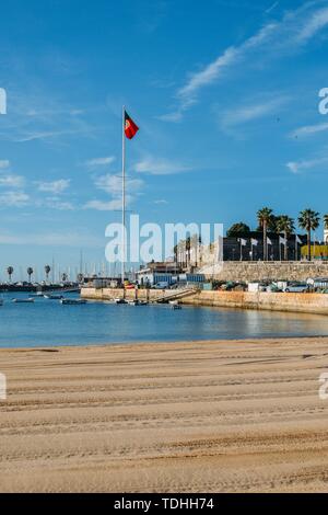 Vide de sable Praia do Ribeiro et bateaux sur une baie d'un matin d'été ensoleillé. Cascais est un petit village pittoresque à 30 km à l'ouest de Lisbonne. Banque D'Images