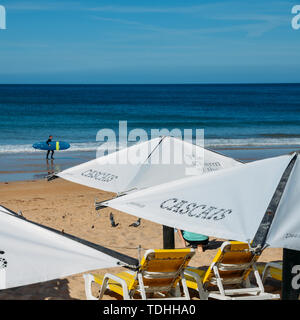 Cascais, Portugal - 10 juin 2019 : Surfez en arrière-plan avec plage parasols et chaises longues à Cascais, Portugal Banque D'Images