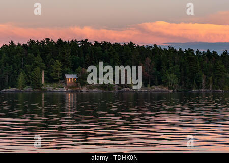 Chalet rustique sur l'île de Rainy Lake at Sunset Banque D'Images