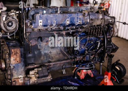 Mécanicien a ouvert la vanne de verrouillage de mécanisme. Démonter le bloc-moteur du véhicule. Ancienne capitale du moteur de réparation. Service de voiture concept. Banque D'Images