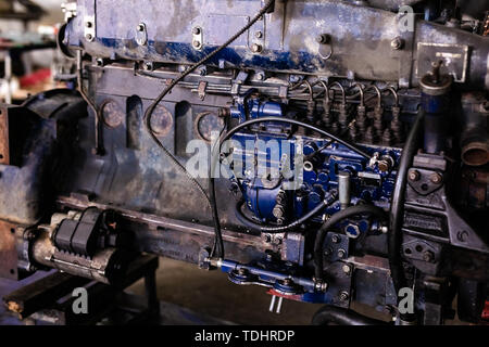 Mécanicien a ouvert la vanne de verrouillage de mécanisme. Démonter le bloc-moteur du véhicule. Ancienne capitale du moteur de réparation. Service de voiture concept. Banque D'Images