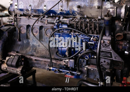 Mécanicien a ouvert la vanne de verrouillage de mécanisme. Démonter le bloc-moteur du véhicule. Ancienne capitale du moteur de réparation. Service de voiture concept. Banque D'Images