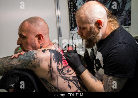 Milton Keynes, Royaume-Uni. Le Royaume-Uni Tattoo Fest a eu lieu à l'Arène Marshall pendant le week-end du 15 et 16 juin 2019. Plus de 190 tatoueurs de travail étaient présents ainsi que les stalles. Photo homme ayant son dos tatoué. Crédit : Stephen Bell/Alamy. Banque D'Images