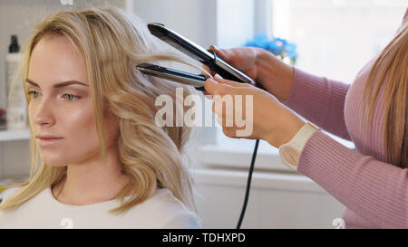 Coiffure coiffure permet au client. Relations sérieuses in délicate et service à la clientèle. L'industrie de beauté. Création de coiffures de soirée élégante à la mode féministe Banque D'Images
