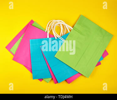 Multi-couleur rectangulaire des sacs en papier avec poignées blanc sur fond jaune, télévision lay Banque D'Images