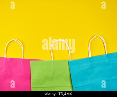 Multi-couleur rectangulaire des sacs en papier avec poignées blanc sur fond jaune, copy space Banque D'Images
