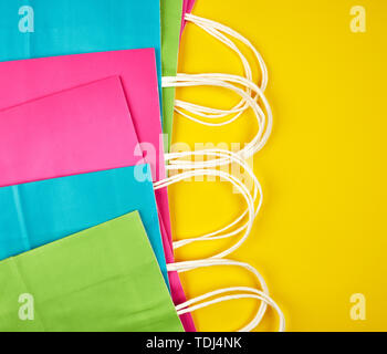 Multi-couleur rectangulaire des sacs en papier avec poignées blanc sur fond jaune, télévision lay Banque D'Images