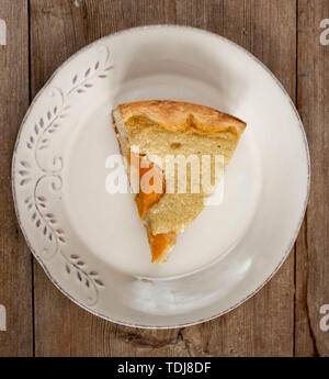 Tranche d'ouvrir pêche abricot tarte aux pommes ou gâteau au fromage blanc sur plaque sur table en bois macro close-up horizontale. Banque D'Images
