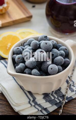 Bleuets servis dans une assiette blanche sur une table avec citrons Banque D'Images
