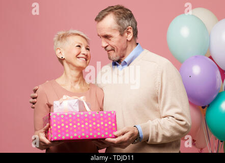 Happy mature couple hugging at tout en célébrant l'anniversaire en studio Banque D'Images