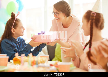 Portrait de jeune fille heureuse de recevoir de cadeaux d'anniversaire maman pendant la fête entre amis, copy space Banque D'Images