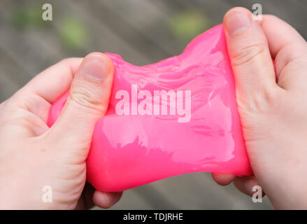 Pink slime anti stress toy en mains. La lutte contre l'anxiété et le stress. Expérience de jeu créatif pour les enfants. Banque D'Images