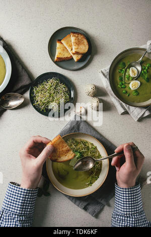 Dîner de départ de l'homme. Variété de légumes vert asperges, brocoli, pois ou décoré par les verts, la crème, l'huile, dans des bols en céramique. Man's hands avec s Banque D'Images