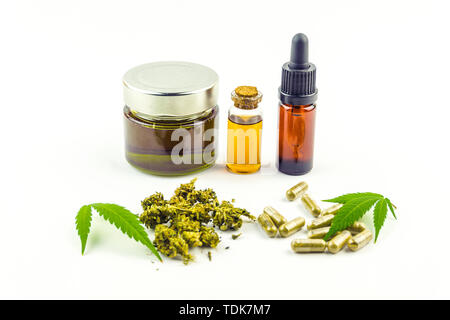 Le cannabidiol CBD de bouteilles en verre d'huile, pilules des boutons de fleurs et feuilles de cannabis isolated on white Banque D'Images