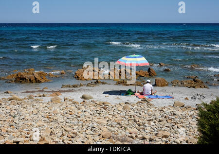 Nuoro, Italie. Le 05 juin, 2019. Un homme s'est assis sous un parasol sur une plage dans le Parc National di Bidderosa dans le golfe d'Orosei. Credit : Jens Kalaene Zentralbild-/dpa/ZB/dpa/Alamy Live News Banque D'Images